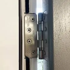 Fire door hinge inspection checking CE marking and secure fixings during a compliance audit